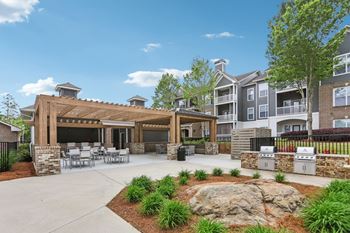 A large outdoor patio area with a stone fireplace and seating area.